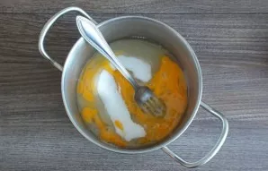 Take the pot. Beat eggs into it, add sugar. Stir.