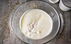 Pour kefir into a bowl and add soda and salt. Mix these ingredients with a whisk.