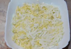 Then grate the eggs in the salad bowl as the first layer. Grease with mayonnaise.