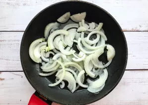 Peel the onions, cut into half rings and fry in vegetable oil until golden brown.