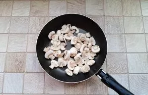 Peel the mushrooms, wash and cut them. Put in a pan with sunflower oil.