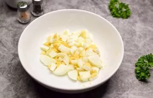 Boil the eggs for 10 minutes, cool and peel. Cut the eggs into small cubes. Transfer eggs to salads.