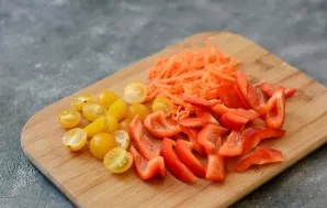 Wash vegetables, dry. Remove the seeds and tails from the peppers, cut into large slices. Peel the carrots and grate. Cut the cherry toma...