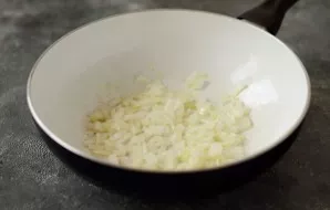 Finely chop the onion, fry in a pan with oil until transparent.