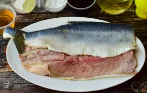 Clean, wash and cut the fish in half.