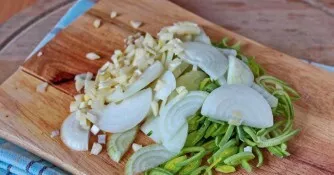 Wash and peel the onions and garlic. Drain and finely chop with a sharp knife.