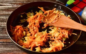Heat vegetable oil in a pan. Add chopped onion and grated carrots. Fry the vegetables for 2-3 minutes.