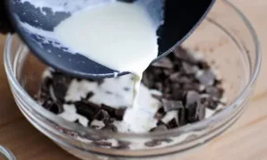 In a small saucepan, heat the cream until bubbles begin to form around the edges. Do not bring to a boil. Pour the hot cream over the cho...