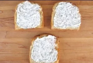Prepare a mixture of soft white cheese, dill and parsley. Spread this mixture on all three slices of bread.