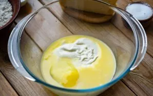 In a saucepan over low heat, melt the butter, cool slightly and pour into a large bowl. Beat an egg into it and add sour cream.
