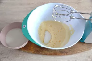 Beat two eggs in a bowl to knead the dough, beat them into a fluffy foam, gradually add sugar without stopping beating.