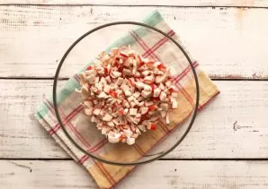 Finely chop the crab sticks and put them on a deep plate.