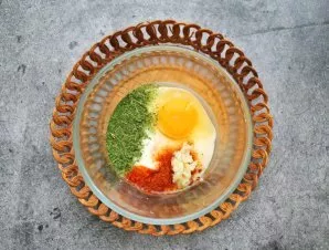 In a bowl, mix sour cream, egg, bell pepper, herbs and chopped garlic. Season everything with salt and black pepper.