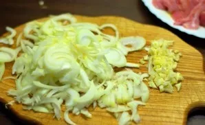 Finely chop the garlic and cut the onion into thin half rings.