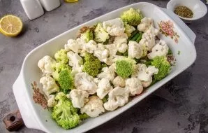 Separate cauliflower and broccoli with inflorescences. Place the green beans and cabbage inflorescences in a baking dish.