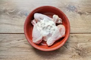 Wash the chicken legs, dry them and put them in a baking dish. Add sour cream.