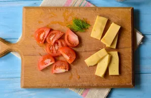 Chop the tomatoes and hard cheese.