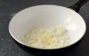 Cut the onion into half rings, chop the garlic finely. Fry in a pan with oil (2 tablespoons) until golden brown.