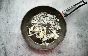 Pour vegetable oil into the pan and heat over medium heat. Cut the onion into half rings and fry for 7 minutes.