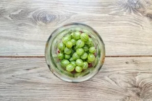 Remove the stems from the gooseberries, rinse and let the water drain completely. Put the berries in a jar with currants.