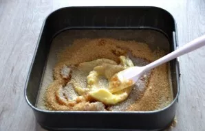 Line the baking sheet with baking paper. Pour brown sugar into the form, add melted butter, stir, evenly smooth the bottom of the mold.