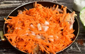 Add chopped onions and carrots to the fried chicken.
