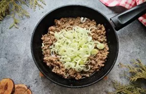 Cut the leeks into rings or half rings and add to the fried mince. Season everything with salt, pepper and fry for another 10-15 minutes ...
