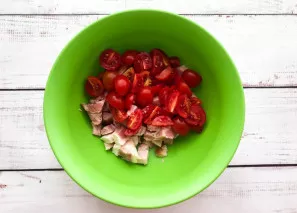 Wash the tomatoes, dry them with a paper towel, cut them into several parts and add them to the ham.