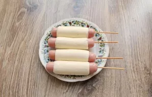 Wrap the sausage on a wooden skewer. Place the cheese overlap side down on a plate and refrigerate for 20 minutes.