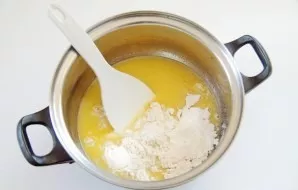 Without lifting the pot from the heat, add flour in parts.