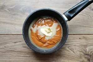 Put the pot on low heat and, stirring, cook over low heat. The mass should become thick, brownish. Pour in the butter and immediately sti...