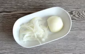 Peel the onion and cut it into thin half rings.