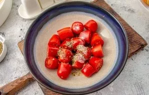 Cut the tomatoes in half. Put the tomatoes in a suitable container, salt to taste, add pepper, dried oregano and olive oil, mix.