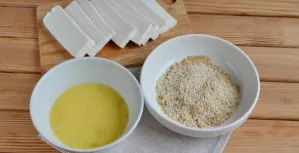 Mix breadcrumbs with sesame seeds. Beat the egg with a fork until smooth. If the cheese is not salty, add salt to taste while beating the...