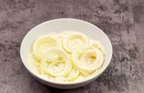 Pour wheat flour into a deep bowl, add salt and pepper, mix. Now sprinkle all the onion blanks with wheat flour.