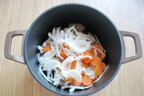 Peel carrots and onions, wash and chop. Put in a saucepan with meat.