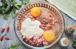 In a bowl with pork, beat the eggs, add sour cream, salt and pepper. Mix everything thoroughly.