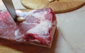 Rinse and dry the brisket. Stuffed with garlic.