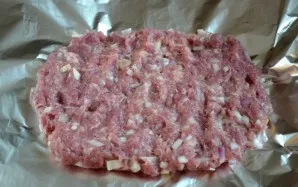 Add an onion to the minced meat, squeeze a clove of garlic, salt and pepper to taste. Place the minced meat on a sheet of foil and form a...