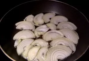 Cut the onion into half rings. Heat vegetable oil in a pan and add onion half rings, fry until transparent.