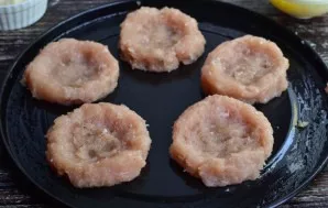 From minced meat form nests and put on a baking sheet (you can anoint with vegetable oil).