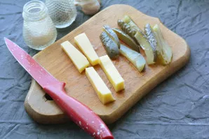 Cut cheese and pickled cucumbers into strips.