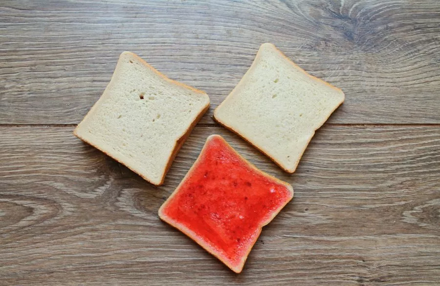 Spread a thick layer of strawberry jam on two slices of toasted bread. Let it sit for a while to absorb. Cover with other slices of bread...