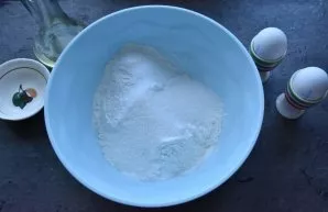 Add sugar to the dry ingredients of the dough and stir the dry mixture with a whisk until all the ingredients are evenly mixed.