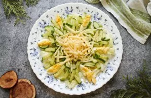 Cut the cucumber into large strips, and grate the cheese on a coarse grater. Put cucumber and cheese on top of the salad.