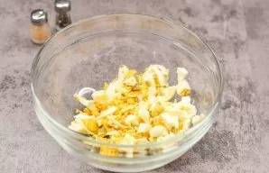 Boil the eggs, then cool and peel. Cut the eggs into cubes and put them in a salad.