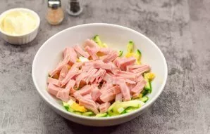 Put the eggs in a salad bowl with cucumbers. Cut the ham into small strips, and also put it in a salad.