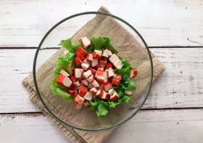 Add finely chopped crab sticks to the salad.
