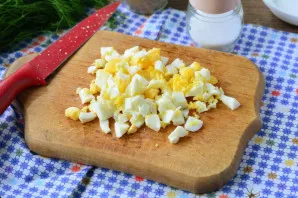 Boil the eggs hard, then cool, peel and cut into cubes.