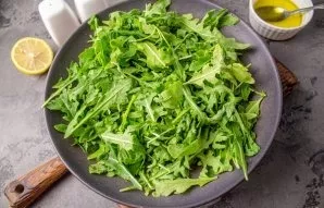 Rinse and dry the leaves of rukola. Put in a salad bowl.
